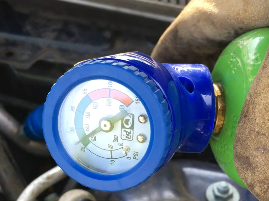 Car AC gas refill and recharge in Qatar using a refrigerant pressure gauge